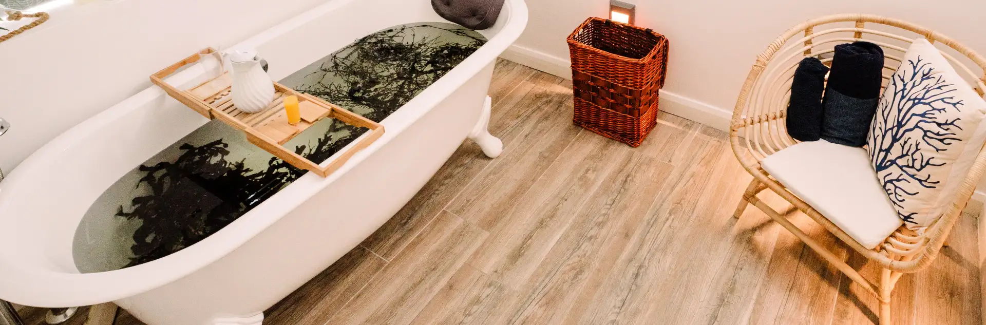 Rattan chair with a seaweed patterned cushion next to a seaweed bath with a serving tray across it